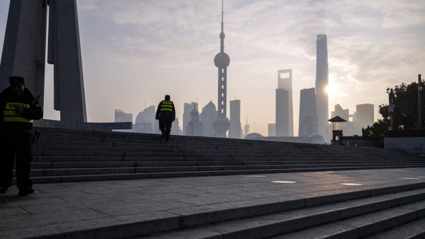 Security guards along the Bund in front of buildings in Pudong's Lujiazui Financial District in Shanghai, China, on Tuesday, Jan. 9, 2024. China's stock market suffers from a lack of positive drivers as the new year begins, and Beijing's support efforts are likely to keep falling flat amid persistent risks. Photographer: Qilai Shen/Bloomberg
