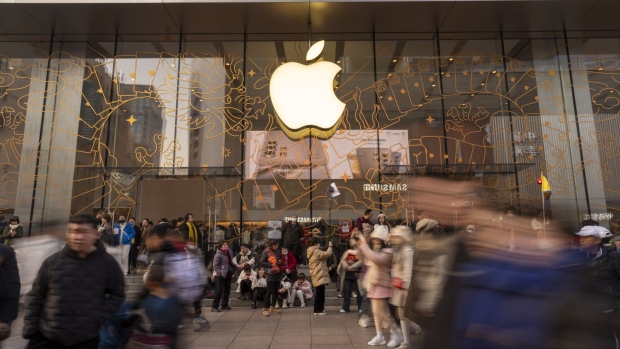 Shoppers pass an Apple Inc. store on East Nanjing Road in Shanghai, China, on Sunday, Feb. 11, 2024. Just over a year after China ended its Covid-Zero policy, the expected bounceback in spending on high-end consumer goods has failed to live up to expectations. Photographer: Raul Ariano/Bloomberg