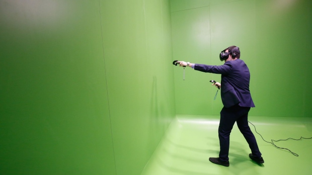 An attendee uses a Vive virtual reality (VR) headset, manufactured by HTC Corp., on the opening day of the Mobile World Congress (MWC) in Barcelona, Spain, on Monday, Feb. 27, 2017. A theme this year at the industry's annual get-together, which runs through March 2, is the Internet of Things. Photographer: Pau Barrena/Bloomberg