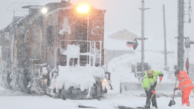 Workers clear train tracks as snow falls north of Lake Tahoe in the Sierra Nevada mountains.