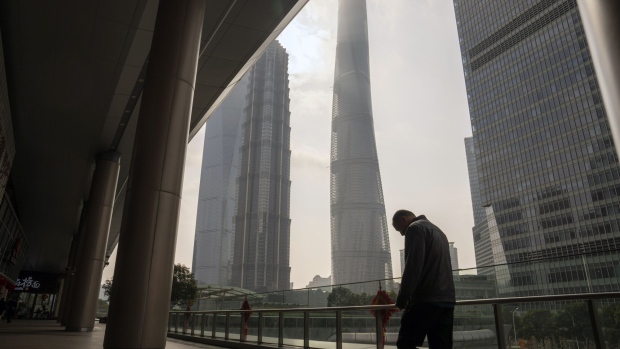Pedestrians in front of buildings in Pudong's Lujiazui Financial District in Shanghai, China, on Monday, Jan. 29, 2024. China will halt the lending of certain shares for short selling from Monday, the securities regulator announced Sunday, in a move to support the country’s slumping stock markets. Photographer: Raul Ariano/Bloomberg