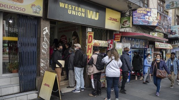 <p>Customers wait in line outside a Western Union location in La Paz, Bolivia.</p>