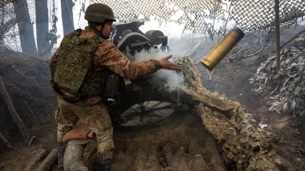 <p>A gunner removes a shell casing after firing the howitzer at Russian positions in Ukraine.</p>