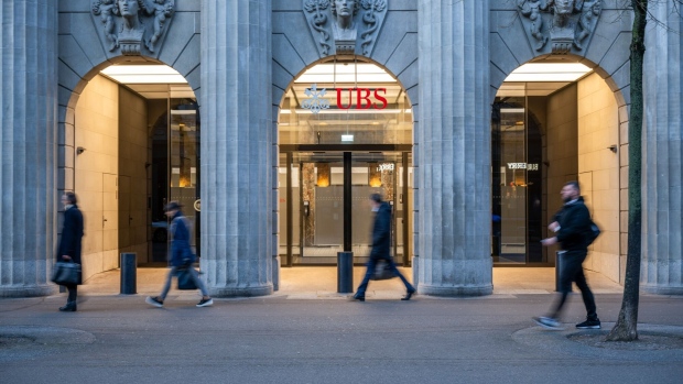 Commuters pass the UBS headquarters in Zurich, Switzerland. Photographer: Pascal Mora/Bloomberg