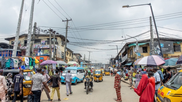 Pedestrians and auto-rickshaws make their way down a street in Lagos, Nigeria, on Saturday, Sept. 24, 2022. Nigeria's inflation rate hit a fresh 17-year high in August, placing renewed pressure on the central bank to increase interest rates. Photographer: Damilola Onafuwa/Bloomberg