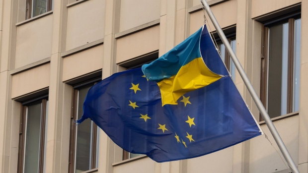The flag of the European Union and the flag of Ukraine outside the European House building in Berlin, Germany, on Friday, Dec. 8, 2023. Chancellor Olaf Scholz and top officials in his governing coalition will reconvene on Monday afternoon to try to seal an agreement on a revised 2024 budget, according to people familiar with the planning. Photographer: Andrey Rudakov/Bloomberg