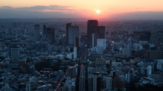 The sun goes down behind commercial and residential buildings in the Minato district of Tokyo, Japan, on Saturday, Oct. 1, 2022. Tankan business confidence and Tokyo CPI data at the start of the week will show the strength of price gains in September and the impact of inflation and global recession concerns on corporate activity. Photographer: Akio Kon/Bloomberg