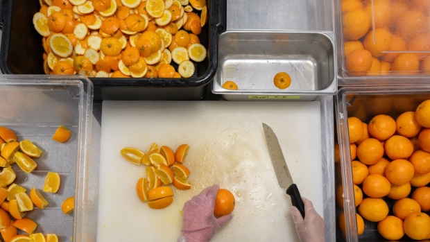 <p>At the Google Bay View campus, a worker cuts oranges while collecting the scraps for composting in Mountain View.</p>