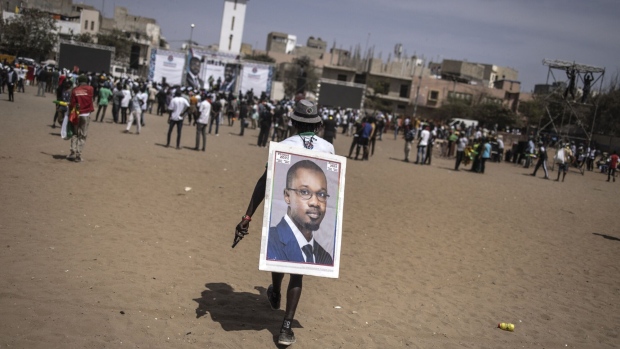 A supporter carries a portrait of Ousmane Sonko in Dakar on March 10. Photographer: John Wessels/AFP/Getty Images