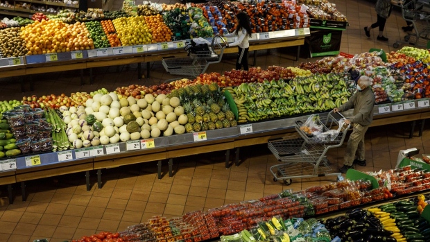 <p>Shoppers walk through produce aisles at a grocery store in Toronto, Ontario.</p>