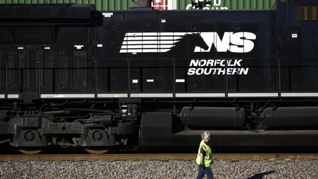 <p>A conductor walks past a Norfolk Southern Corp. freight train in Burnside, Kentucky.</p>