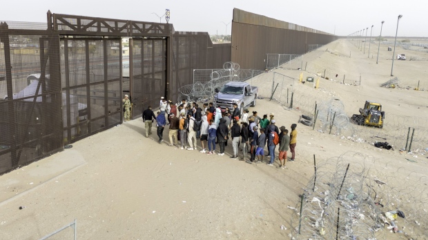<p>Immigrants wait for transport and processing after crossing the US-Mexico border in El Paso, Texas on March 13.</p>