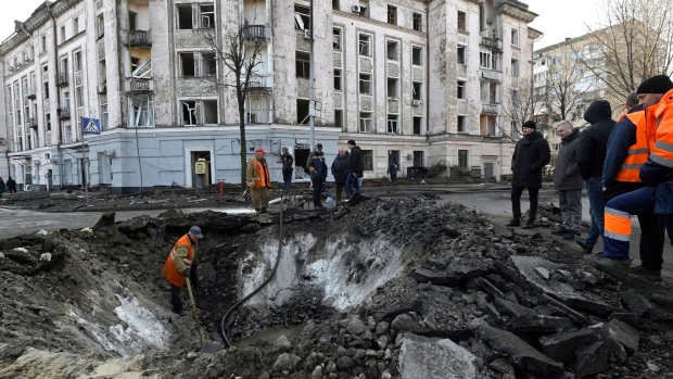 Ukranian municipal services workers survey and repair damage following a missile attack in Kyiv, on March 21. Photographer: Sergei Chuzavkov/AFP/Getty Images