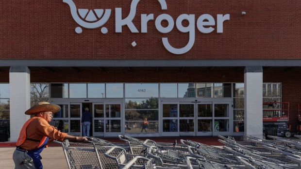 A worker pushes shopping carts outside a Kroger grocery store in Dallas, Texas, US, on Wednesday, Feb. 21, 2024. The US Federal Trade Commission and a group of states are poised to sue as soon as next week to block the tie-up between supermarket giants Kroger Co. and Albertsons Cos., according to people familiar with the plans. Photographer: Shelby Tauber/Bloomberg