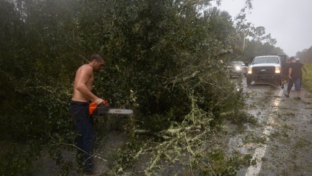 Residents try to cut their way through downed trees to return to their homes following Hurricane Idalia in Steinhatchee, Florida, US, on Wednesday, Aug. 30, 2023. Hurricane Idalia knocked out power to hundreds of thousands of Florida customers, grounding more than 1,800 flights and unleashing floods along far from where it came ashore as a Category 3 storm earlier Wednesday. Photographer: Christian Monterrosa/Bloomberg