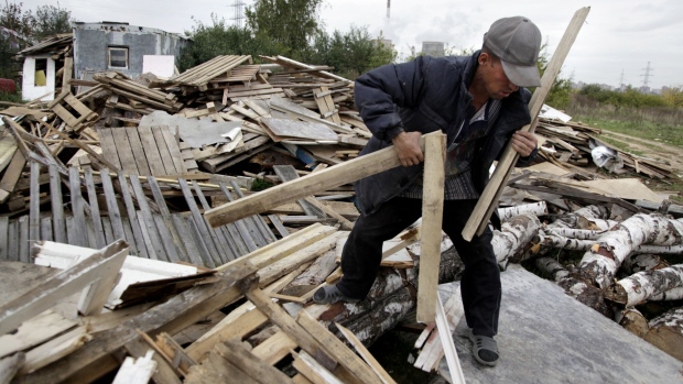 A Tajik migrant worker gathers wood in Moscow. Photographer: Oxana Onipko/AFP/Getty Images
