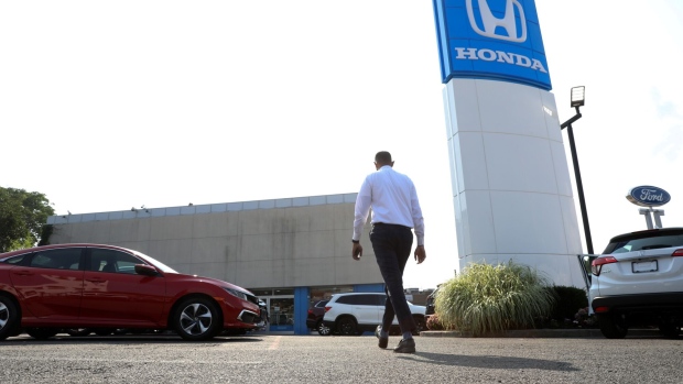 A worker walks through the lot of Paragon Honda and Acura car dealership in the Queens borough of New York, U.S., on Thursday, July 15, 2021. Soaring used-car prices accounted for more than one-third of the recent increase in the consumer price index, which in June rose at the fastest rate in 13 years. Photographer: Bess Adler/Bloomberg