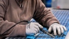 <p>An employee solders solar panel cells at a manufacturing facility in Dalton, Georgia.</p>