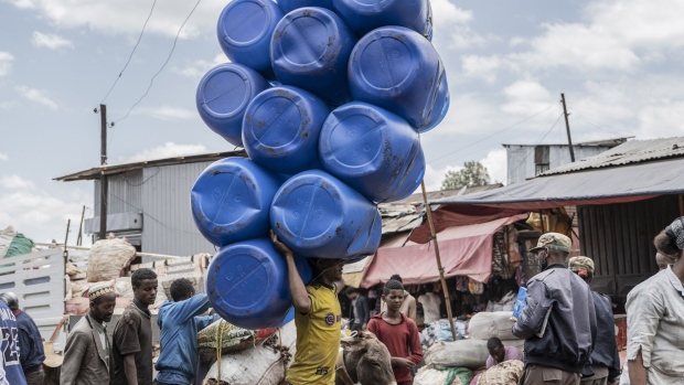 A worker carries plastic barrels on his head through the Merkato area of Addis Ababa, Ethiopia, on Wednesday, Oct. 19, 2022. The International Monetary Fund forecasts economic expansion in Ethiopia will slow to 3.8% this year, with the nation also facing a severe shortage of foreign currency and soaring consumer prices. Photographer: Amanuel Sileshi/Bloomberg