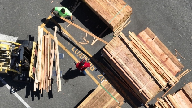 Workers stack lumber in San Rafael, California.