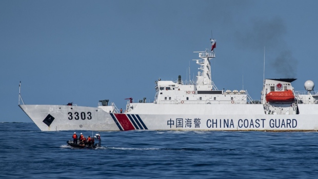 A boat carrying Philippine Coast Guard personnel moves past a China Coast Guard ship during a resupply mission in the disputed South China Sea, on Friday, Nov. 10, 2023.