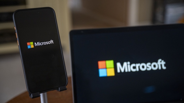 The Microsoft logo on a smartphone and laptop arranged in Crockett, California, US, on Friday, Dec. 29, 2023. Microsoft has invested some $13 billion in OpenAI and integrated its products into its core businesses, quickly becoming the undisputed leader of AI among big tech firms. Photographer: David Paul Morris/Bloomberg