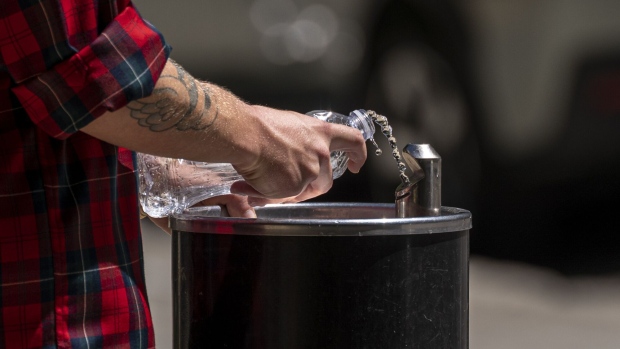 A resident fills a bottle with water from a drinking fountain during a heatwave in Sacramento, California, U.S., on Thursday, July 8, 2021. Another round of wilting heat bearing down on the U.S. West will put further pressure on electric grids and raise fire risks across the region before reaching a peak by weeks end.