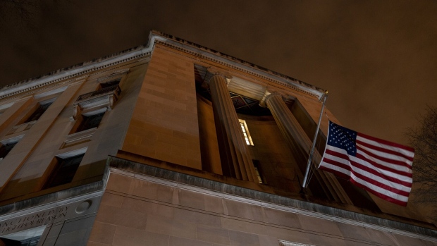 An American flag outside the Department of Justice building before dawn in Washington, D.C., U.S., on Tuesday, Feb. 9, 2021. The Senate begins Donald Trump's second impeachment trial today with a fight over whether the proceeding is constitutional, as a number of conservative lawyers reject the defense teams claim that a former president can't be convicted of a crime by Congress. Photographer: Stefani Reynolds/Bloomberg
