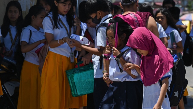 A student uses a bag to protect herself from the sun during a hot day in Manila on April 2. Photographer: Jam Sta Rosa/AFP/Getty Images