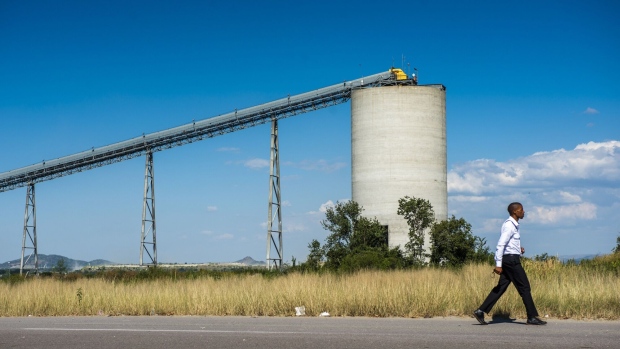 <p>A resident passes a conveyor of a Sibanye Stillwater Ltd. mine in Rustenburg, South Africa.</p>