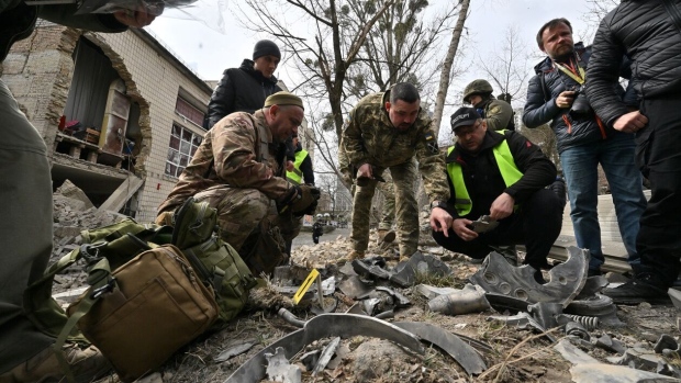 Ukrainian law enforcement officers examine fragments of a rocket at the site of a missile attack in Kyiv on March 25. Photographer: Sergei Supinsky/AFP/Getty Images