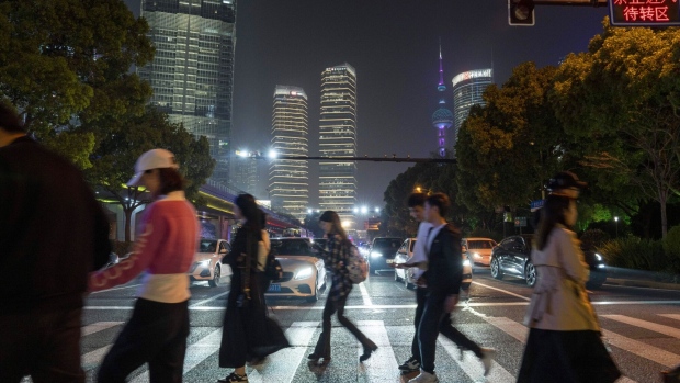 Pedestrians cross a road in Pudong's Lujiazui Financial District in Shanghai. Photographer: Raul Ariano/Bloomberg
