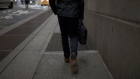 A pedestrian walks along a street near the New York Stock Exchange. Photographer: Jordan Sirek/Bloomberg