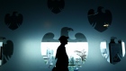 A silhouetted security guard is seen through the Barclays logo at a branch in Karachi.