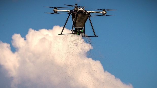 A drone drops seeds during a flight at the Dendra Systems test field in Singleton, New South Wales, Australia, on Thursday, Oct. 1, 2020. Australia-based Dendra Systems which uses specialized drones to survey vast areas of scorched land and produce an action plan to restore plant and tree life says it can turbo-charge forest re-growth in the aftermath of devastating wildfires. The drones can then be used to sow seeds of native species much faster than traditional manual planting methods, at the same time providing a constant flow of real-time data on the progress of regeneration. Photographer: David Gray/Bloomberg