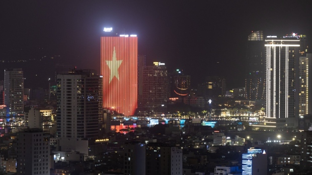 An illuminated Vietnamese flag on a building at night in Da Nang, Vietnam. Photographer: SeongJoon Cho/Bloomberg