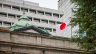 A Japanese flag flies outside the Bank of Japan headquarters. Photographer: Shoko Takayasu/Bloomberg
