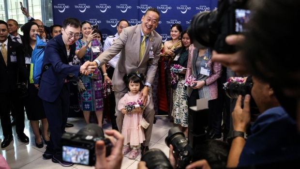 Srettha Thavisin, center, poses for photographs with visitors during an event to welcome inbound tourists from China at Suvarnabhumi Airport in Bangkok in Sept. 2023.