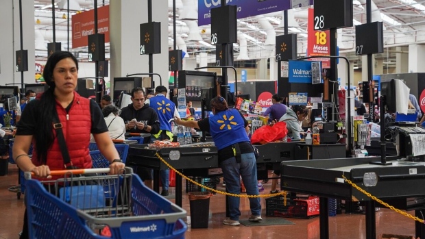 Employees assist shoppers at check out counter inside a Walmart Supercenter store in Mexico City, Mexico.