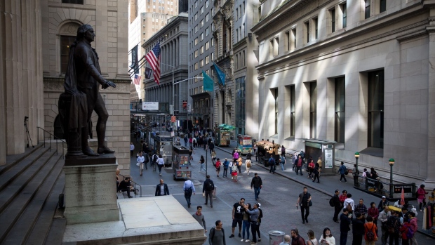 Pedestrians walk along Wall Street near the New York Stock Exchange (NYSE) in New York, U.S., on Friday, May 24, 2019. U.S. equities climbed at the end of a bruising week in which escalating trade tensions dominated markets. Photographer: Michael Nagle/Bloomberg