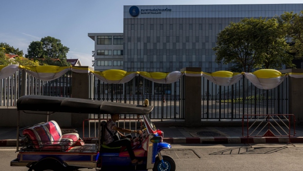 <p>A tuktuk passes the Bank of Thailand complex in Bangkok.</p>
