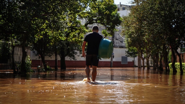A resident walks through floodwater following heavy rains in Porto Alegre, Rio Grande do Sul state, Brazil, on Monday, May 6, 2024. Heavy rains over the state of Rio Grande do Sul caused record-breaking flooding as rivers overflowed, straining dams and displacing more than 88,000 people in more than 330 municipalities and killing at least 75 people with another 103 missing. Photographer: Carlos Macedo/Bloomberg