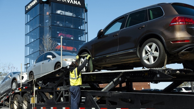 <p>A worker loads vehicles at a Carvana vending machine location in Uniondale, New York.</p>
