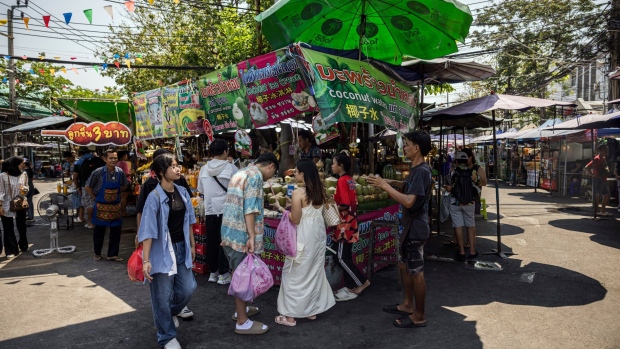 Customers gather at a coconut water and ice cream stall at Chatuchak Market during high temperatures in Bangkok, Thailand, on Sunday, April 28, 2024. Southeast Asia’s second-largest economy has been bracing for hotter-than-normal days due to the El Nino weather pattern that’s forecast to last until June. Photographer: Andre Malerba/Bloomberg
