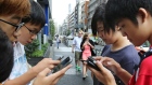 Japanese students play "Pokemon Go" in Tokyo