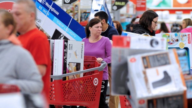 A woman maneuvers her way through Black Friday shoppers at the Target store in Plainville, Mass.
