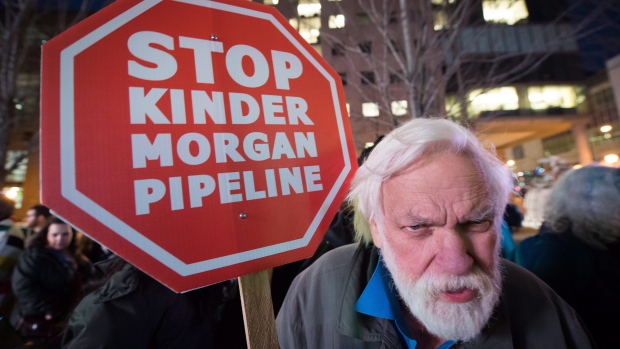Paul George holds a sign during a protest against the Kinder Morgan Trans Mountain project