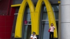 A security guard rests near a giant logo for McDonald in northern China's Tianjin Municipality