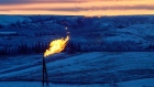 A natural gas flare on an oil well pad burns as the sun sets outside Watford City, North Dakota 