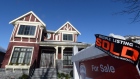 A real estate sold sign is shown outside a house in Vancouver